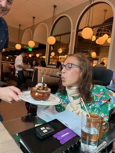 Sheri blowing out the birthday candle in the apple bread pudding with ice cream dessert she shared with her friend Chris at the restaurant Salt Line, 6-22.