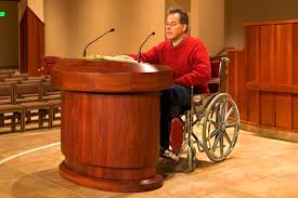 Wheelchair user at a lectern on an altar.