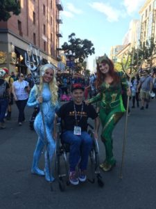 A wheelchair user with two cosplayers