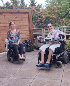 Two people sitting in powerchairs.