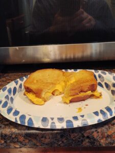 A grilled cheese sandwich on a paper plate.
