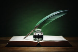 Quill pen, ink bottle, and an open book.