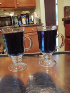 Two glass mugs of purple tea.