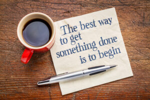 The best way to get something done is to begin - inspirational phrase on a napkin with cup of coffee.