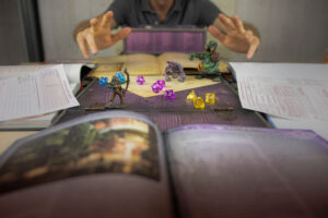 A picture of a Dungeon Master rolling dice in a game of Dungeons & Dragons.