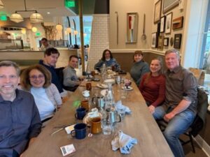 A group of friends sitting around a table, at a restaurant.