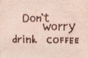 The words "Don't worry drink coffee" written with coffee beans..