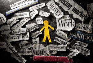 Paper figure surrounded by various depressing news headlines.